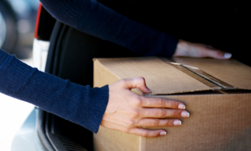 Woman putting box in trunk